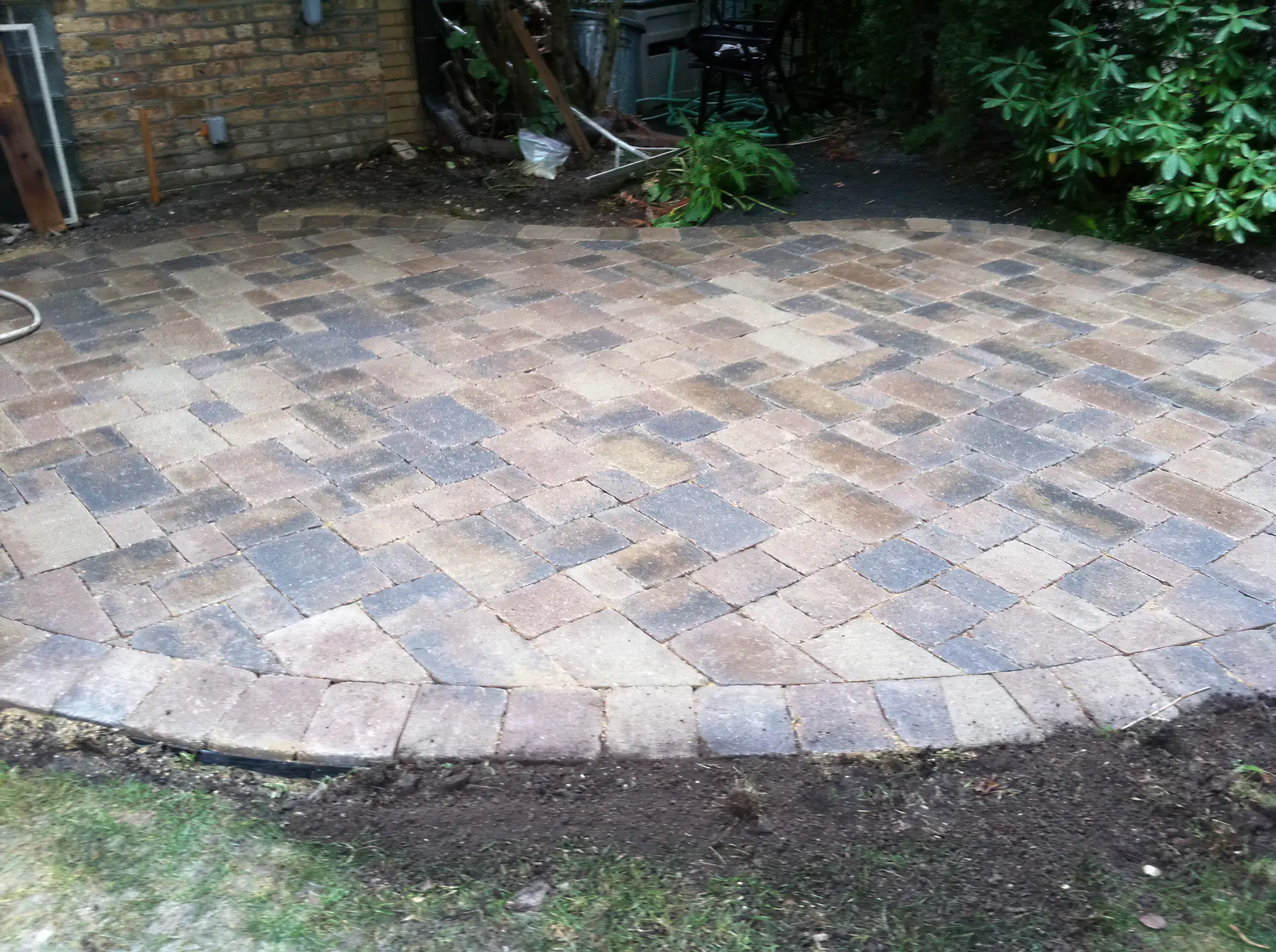 compact kidney-shaped patio with varied colored stone